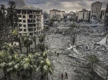 Residents walk through the rubble of the Al-Remal neighborhood in Gaza City after it was destroyed by air raids. © Eyad Baba for Kindness Beyond Borders Charity Innitiative